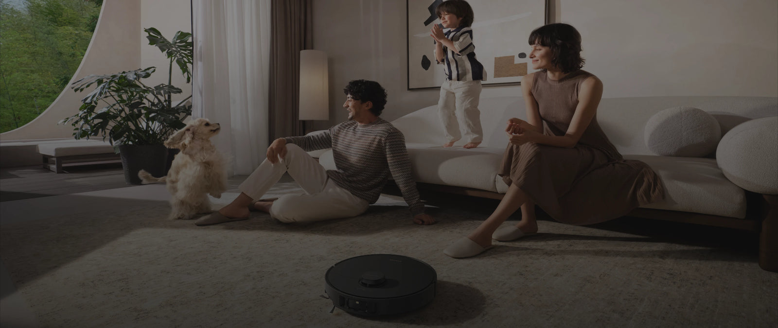 De Dreame Matrix10 Pro robotstofzuiger Zwart reinigt intelligent op de achtergrond terwijl het gezin ongestoord samen geniet.