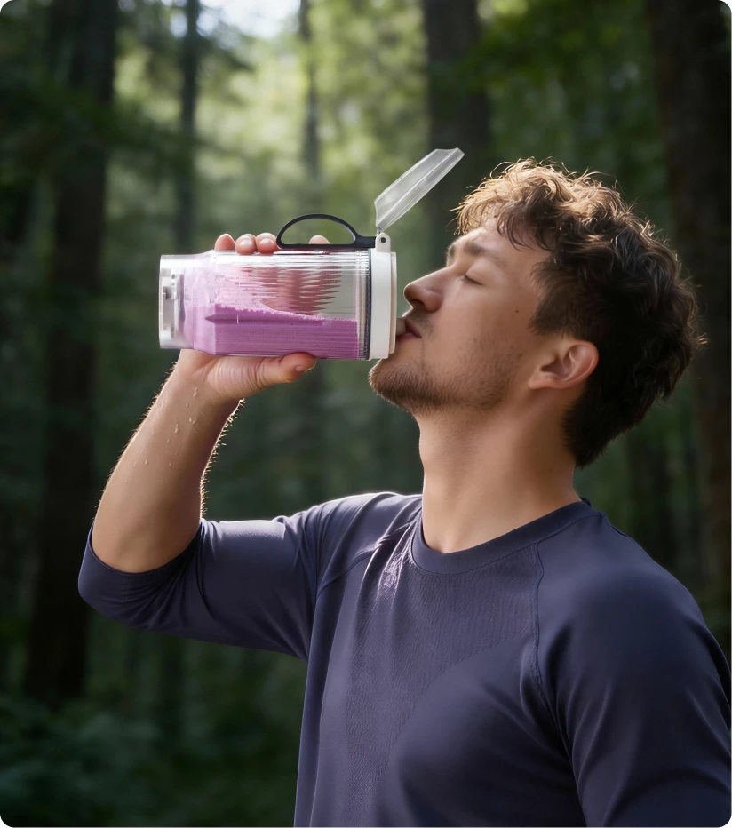 Gebruiker drinkt een smoothie uit de draagbare Dreame Portable Blender beker tijdens een boswandeling